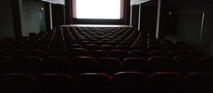 Salle de cinéma avec écran et rangées de sièges
