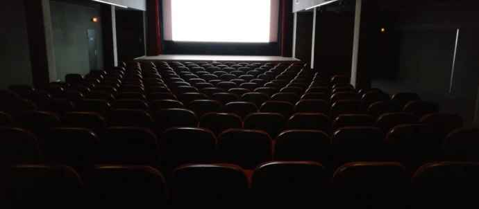 Salle de cinéma avec écran et rangées de sièges